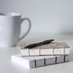 deux carnets, stylo et tasse